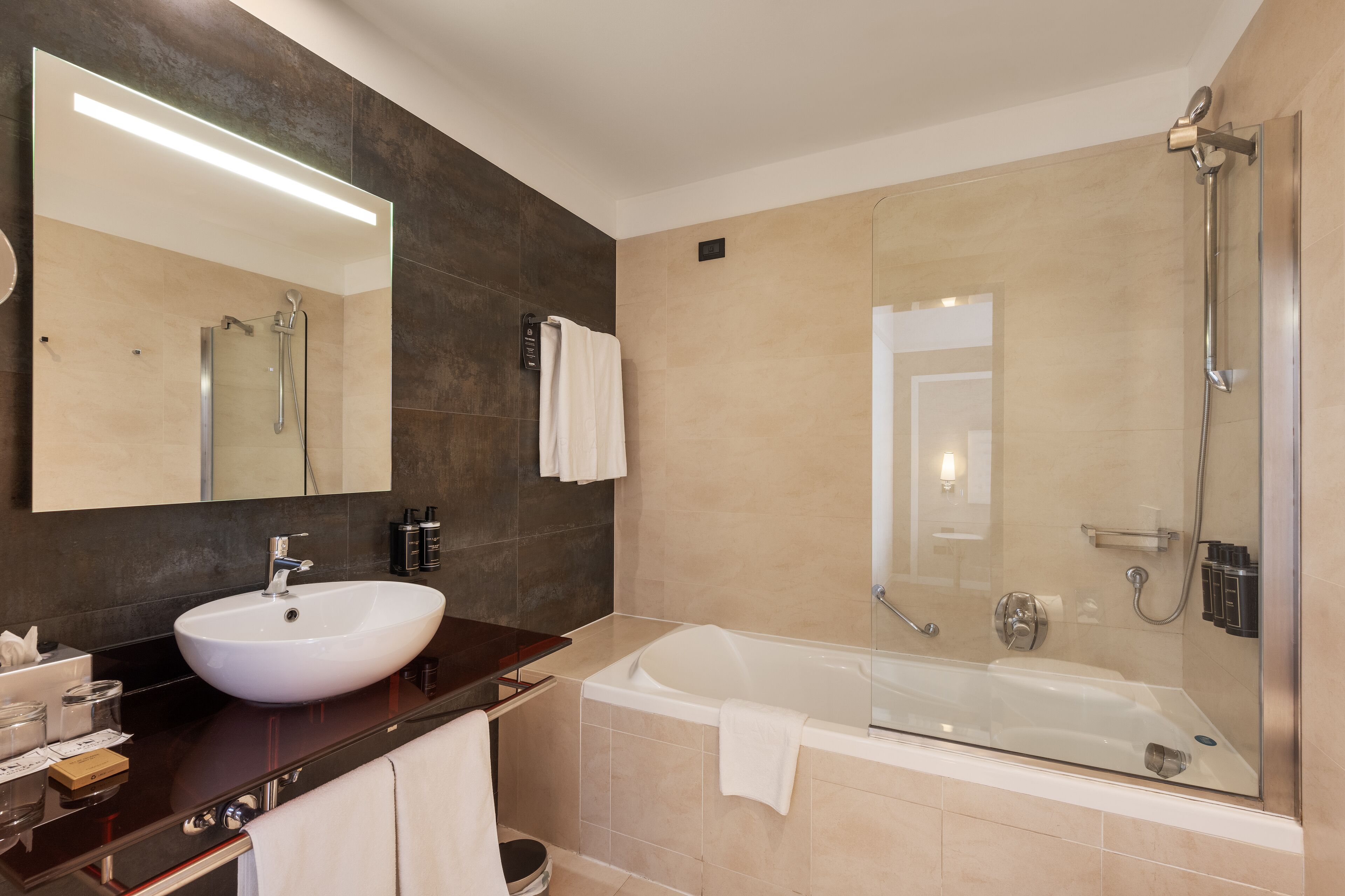 A modern bathroom with a large sink, a bathtub, and a shower.