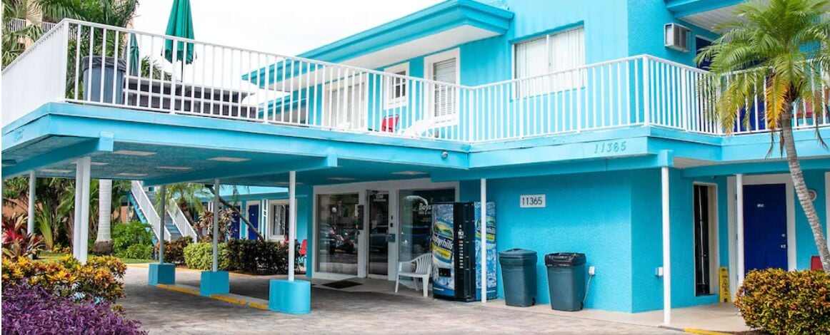 A blue building with a balcony, a covered entrance, and a number 11365.