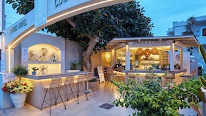 A hotel exterior with a bar named "Drinks & Coffee" and a sign for "Studio's Hotel." - Mila Malia Studios Hotel  (Hersonissos)