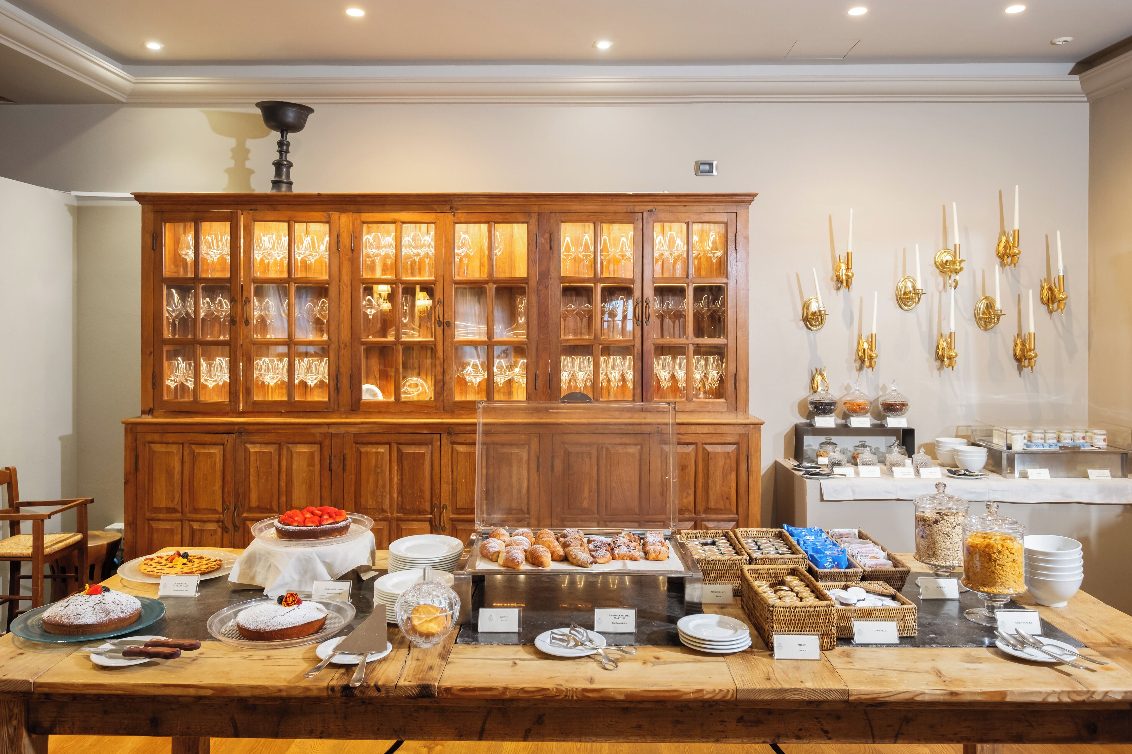 A buffet setup with various food items and glassware.