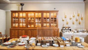 A buffet setup with various food items and glassware.
