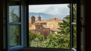Vista desde una ventana sobre un pueblo histórico con arquitectura tradicional y un campanario destacado.