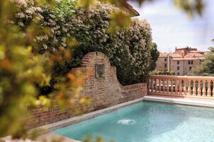 Una piscina al aire libre de temporada, sillones reclinables de piscina