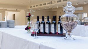 A table with wine bottles, glasses, and a bowl of corks. - Wall Art Hotel (Prato)