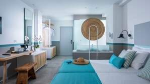 A modern hotel room with a wooden desk, a large mirror, a bed with teal bedding, and a woven basket on the bed. - Solimar Turquoise Adults Only - All Inclusive (Chania)