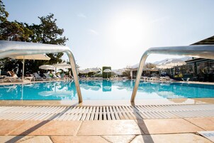 Una piscina al aire libre de temporada, sombrillas