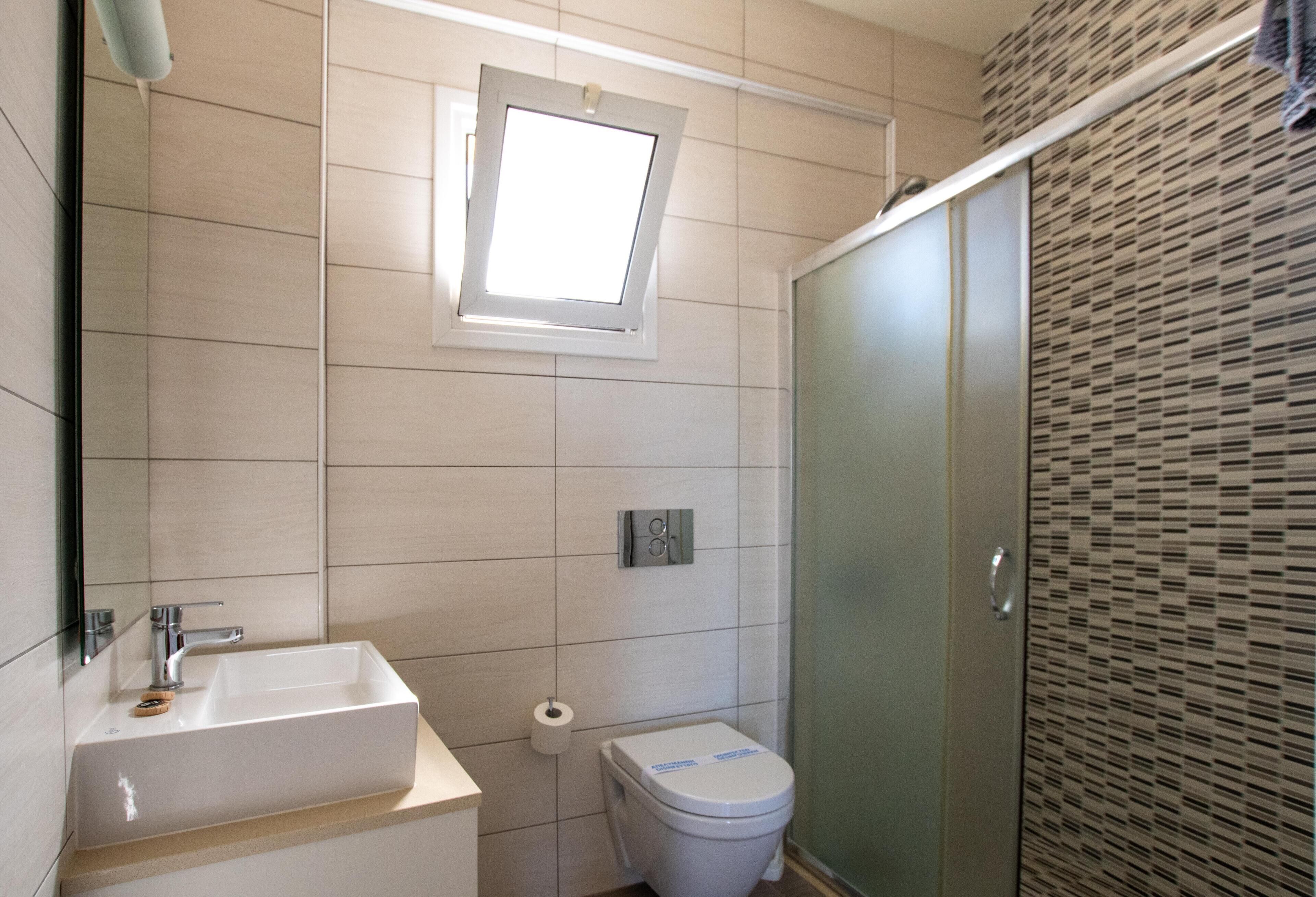 Une salle de bain équipée d’un lavabo, de toilettes et d’un espace douche.