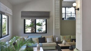 Una sala de estar moderna con un sofá, una mesa de centro y una planta grande en maceta.