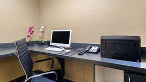Un escritorio de recepción de hotel con una computadora, teléfono e impresora.