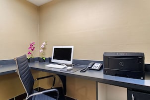 Un escritorio de recepción de hotel con una computadora, teléfono e impresora.