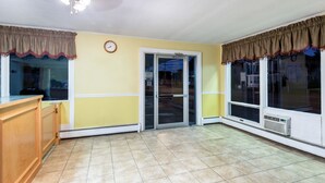 A spacious room with a large window, a door, and a wooden counter. - Relax Inn (Brunswick)