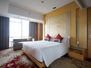 Relax in a spacious room with a large bed, nightstand, and comfortable seating area.