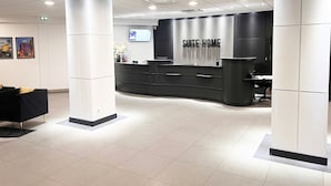 A modern reception desk with a 'SUITE-HOME' sign, a black and white color scheme, and a clean, tiled floor. - Suite Home Briancon Serre Chevalier (Briançon)