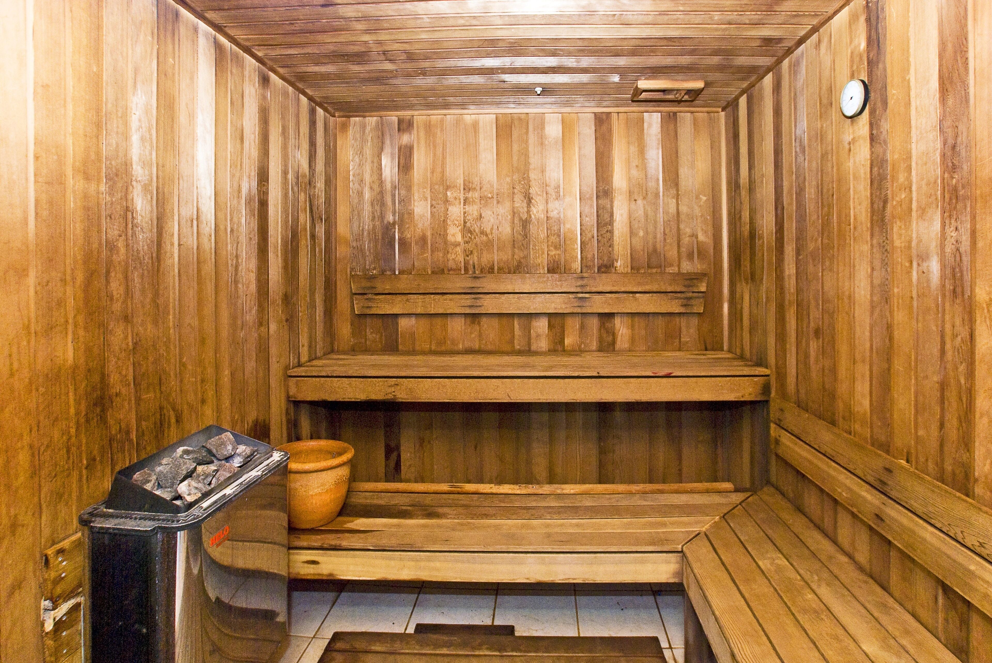 Una sauna con bancos de madera y un calentador.