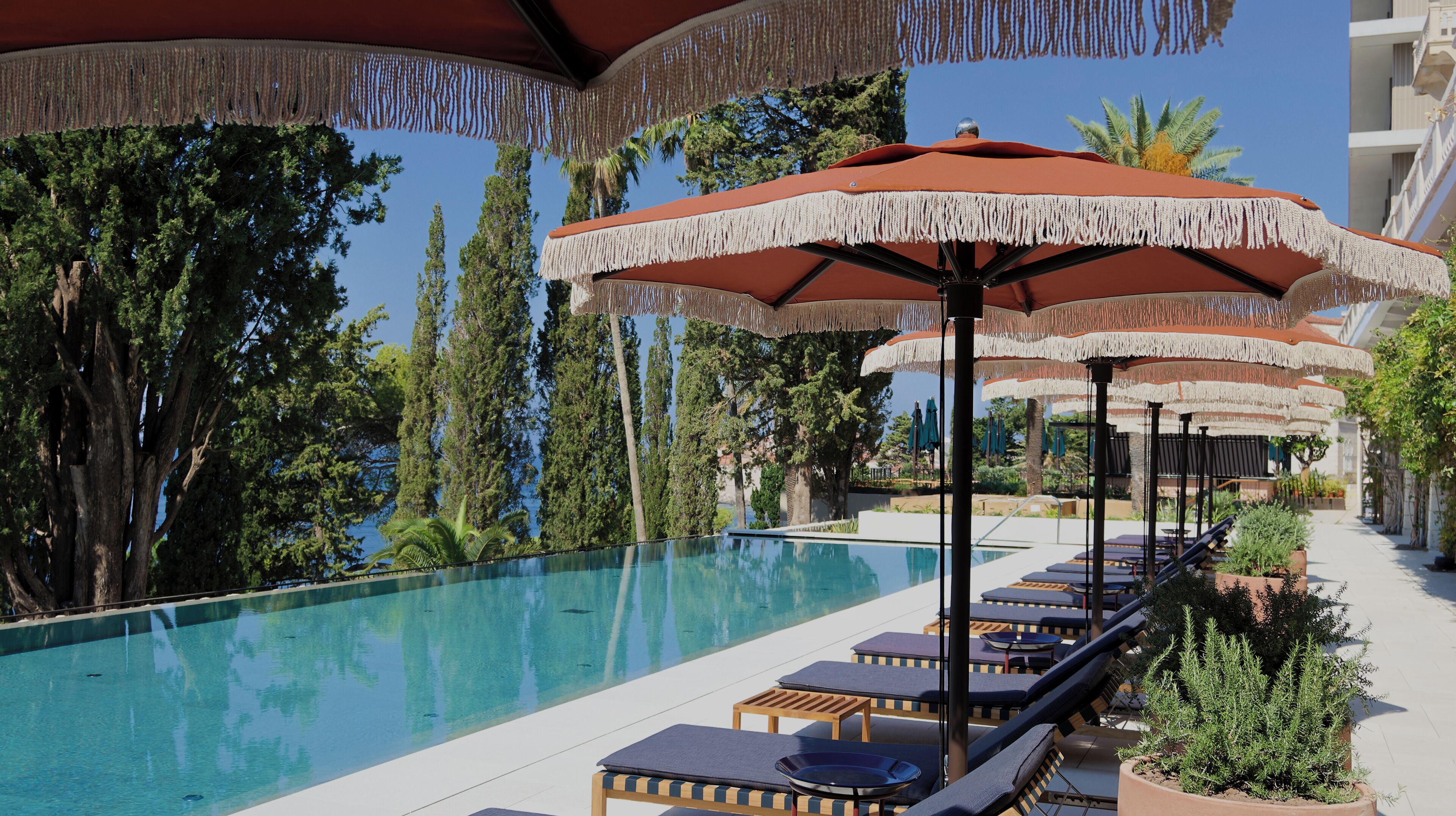 Un espace aménagé au bord de la piscine, avec des chaises longues et des parasols.