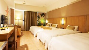 Habitación de hotel con tres camas, un escritorio, un televisor y un cuadro de palmeras.