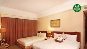 A hotel room with two beds, a large window with curtains, a painting on the wall, and a logo on the wall. - The Fisher Hotel (New Taipei City)