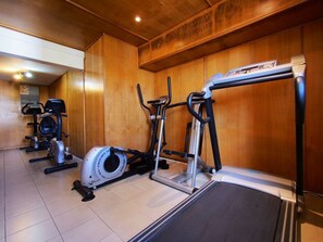 A gym with various exercise equipment including treadmills, stationary bikes, and elliptical machines. - Gold Beach Resort (Flic-en-Flac)