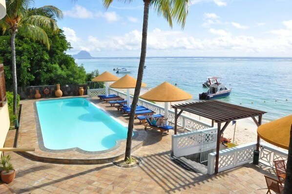 Una piscina al aire libre, sombrillas