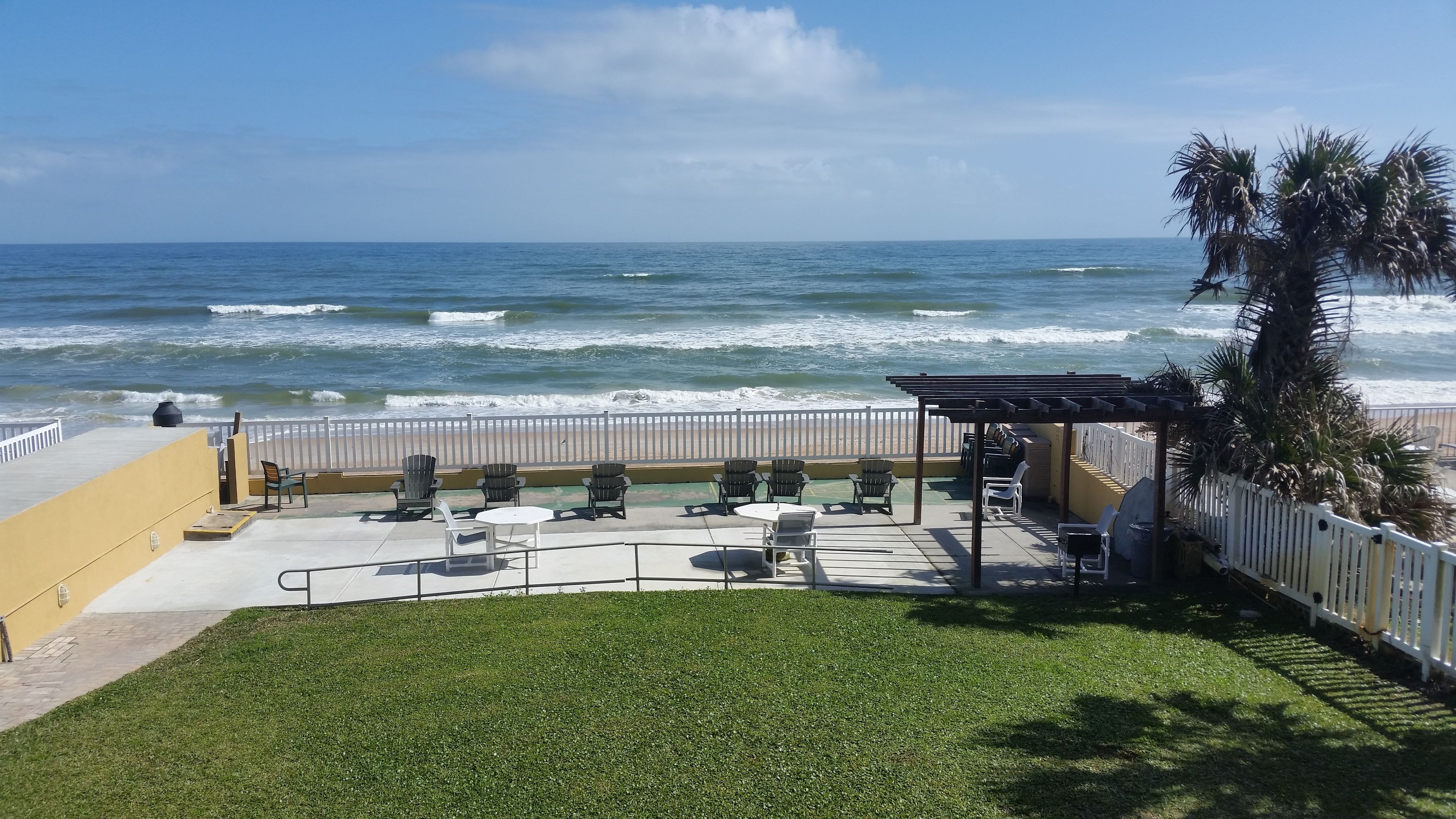 A patio with outdoor seating overlooking the ocean.