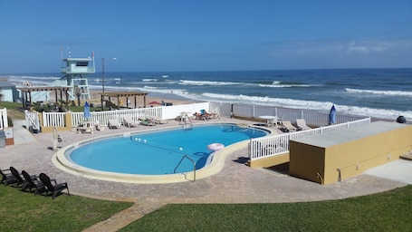 Una piscina al aire libre, sombrillas