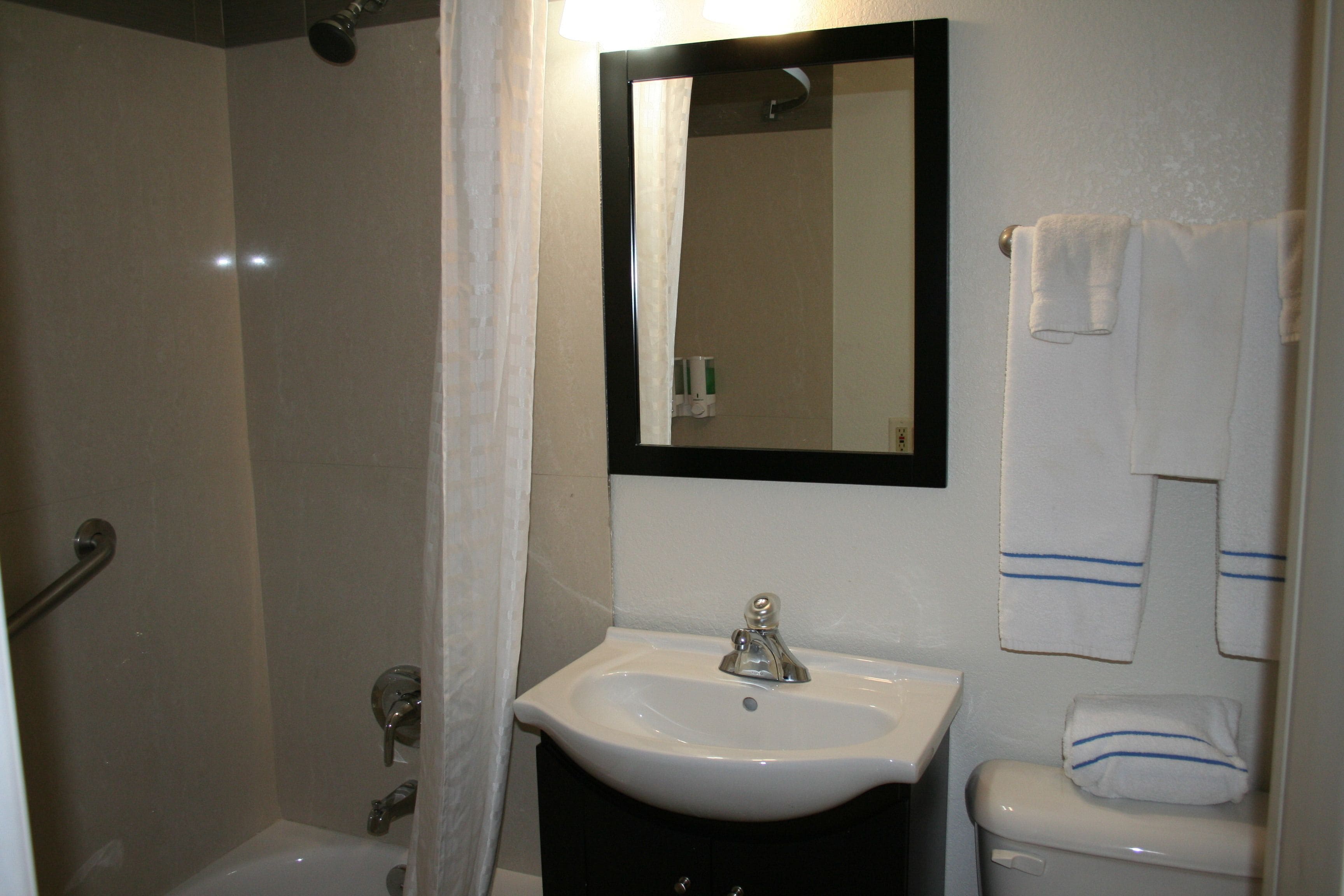 Ein Badezimmer mit Dusche, Waschbecken und Toilette.