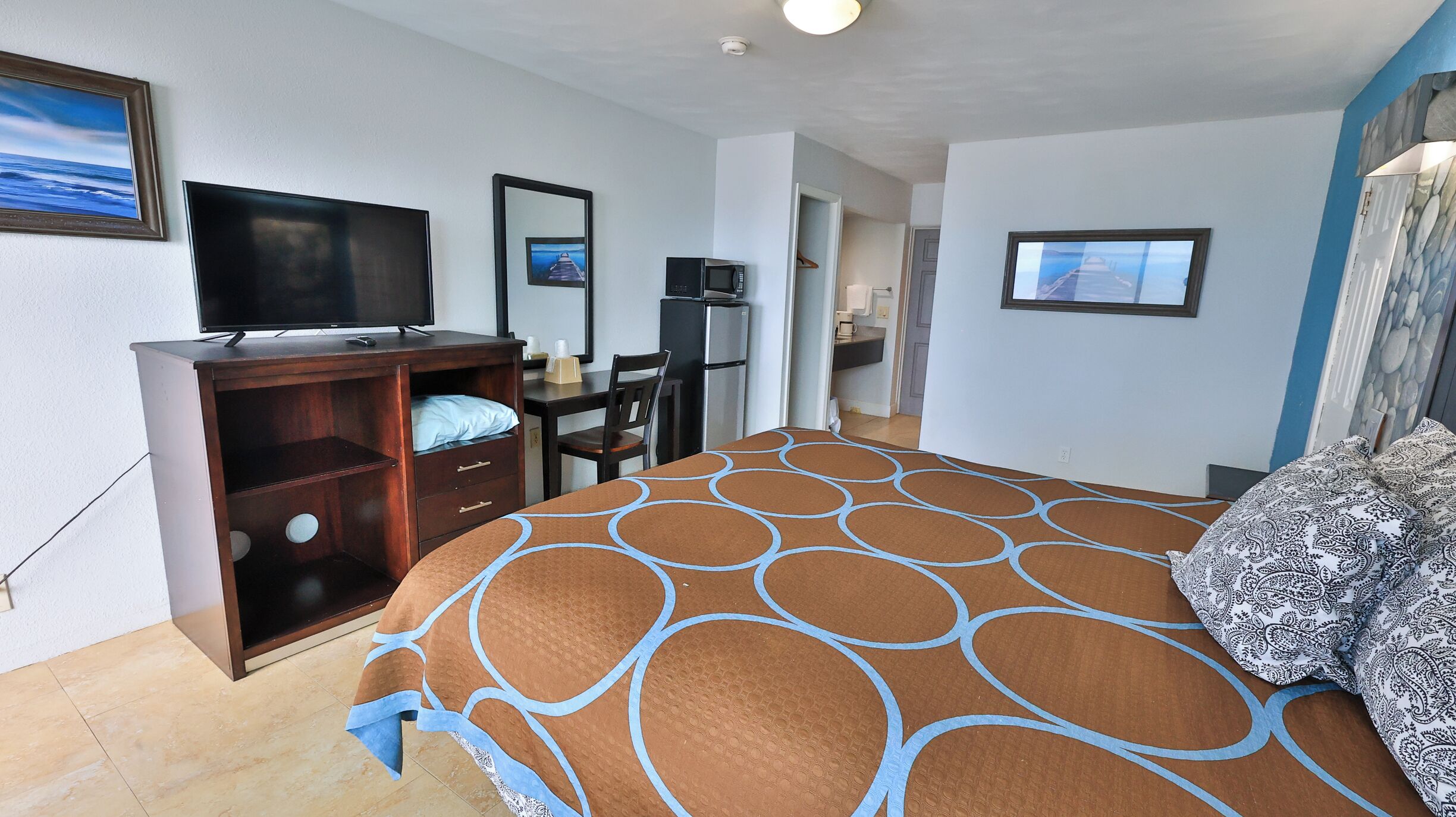 A hotel room with a bed, a TV, a desk, and a wardrobe.