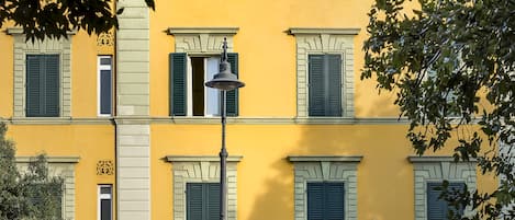 Un edificio amarillo con contraventanas verdes y un letrero que dice 'Hotel del Corso'.