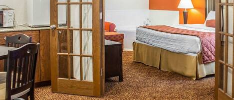 Une chambre d’hôtel comprenant un lit, un bureau avec une chaise, une table et une lampe.