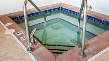 A swimming pool with two metal ladders, a blue tiled border, and a 'No Diving' sign.