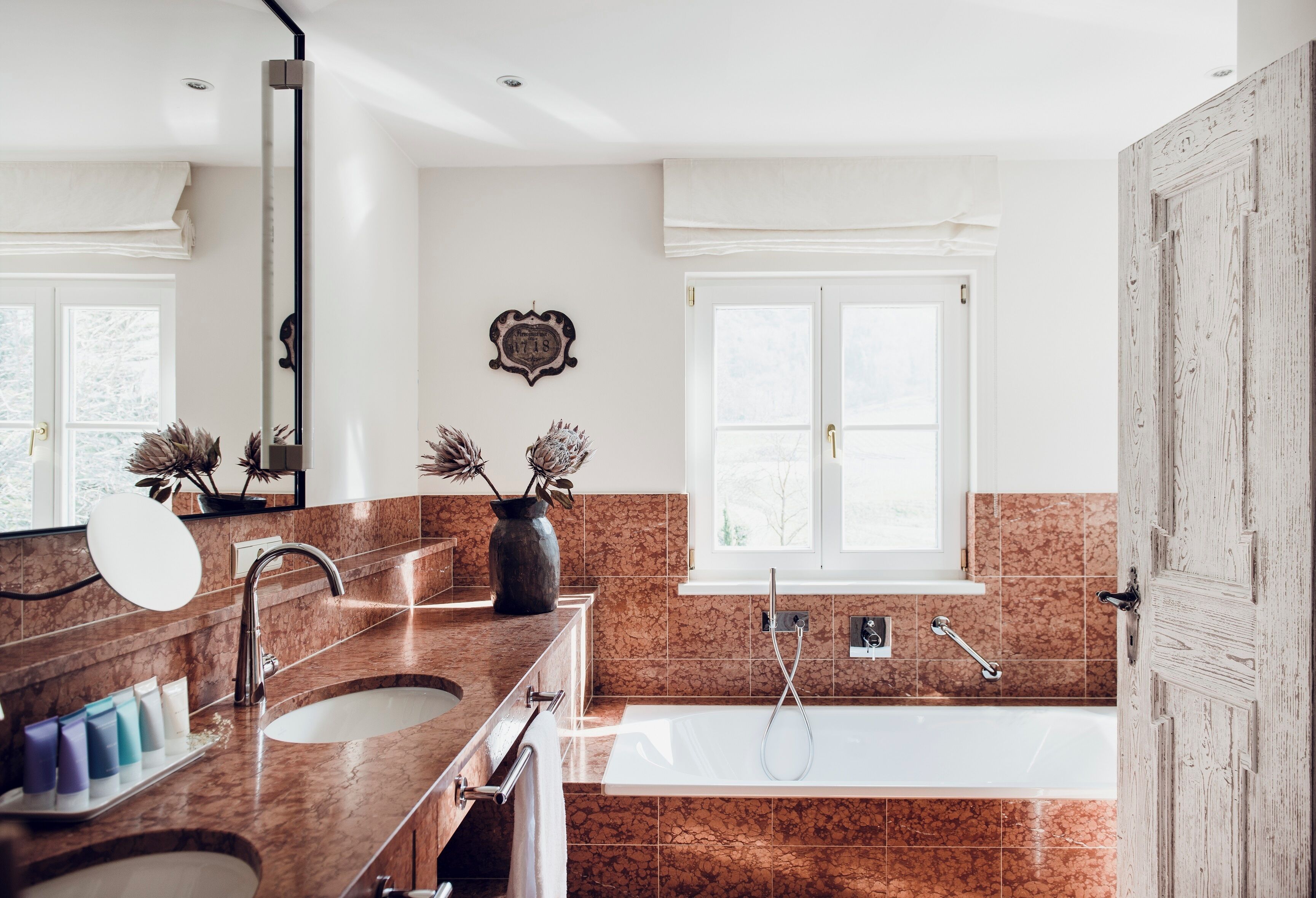 Un bagno moderno con un lavandino grande, un mobile bagno e una vasca freestanding.