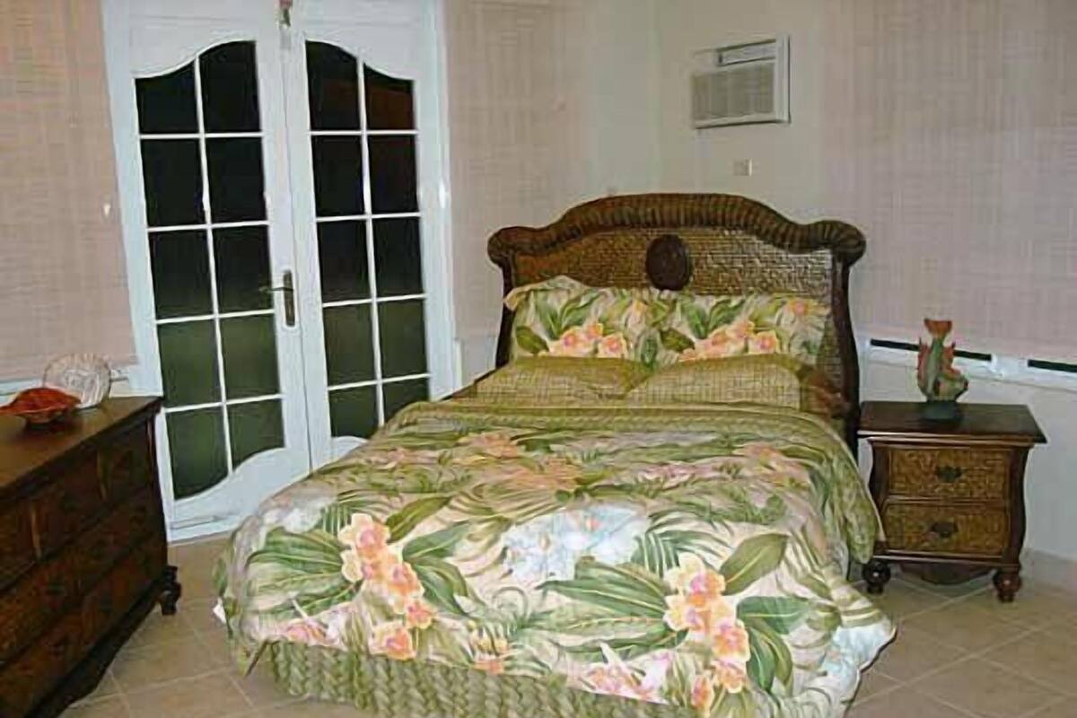 A bedroom with a bed, a dresser, and a nightstand.