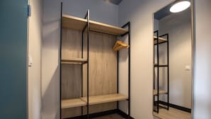 A walk-in closet with wooden shelves and a mirror. - Font Andorra Hostel by Nexta (La Massana)