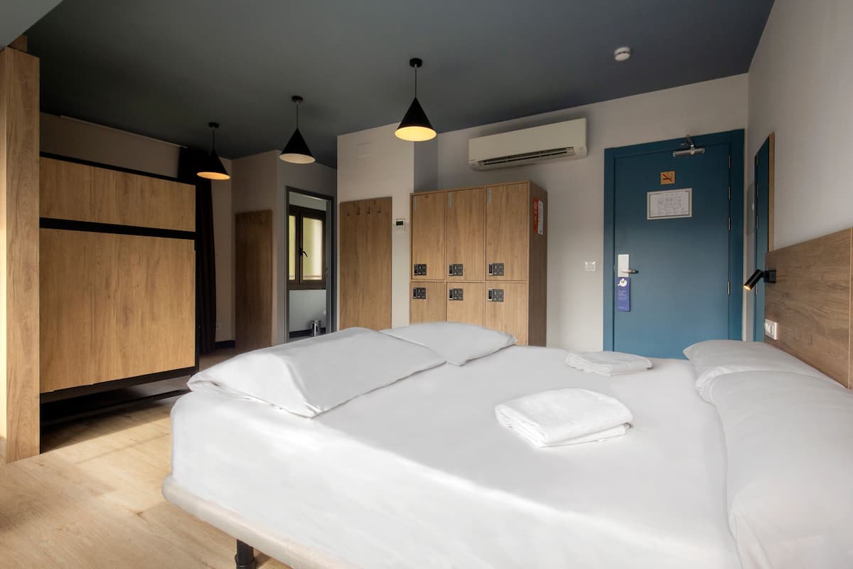 Habitación de hotel con una cama grande, un armario de madera y una puerta azul.