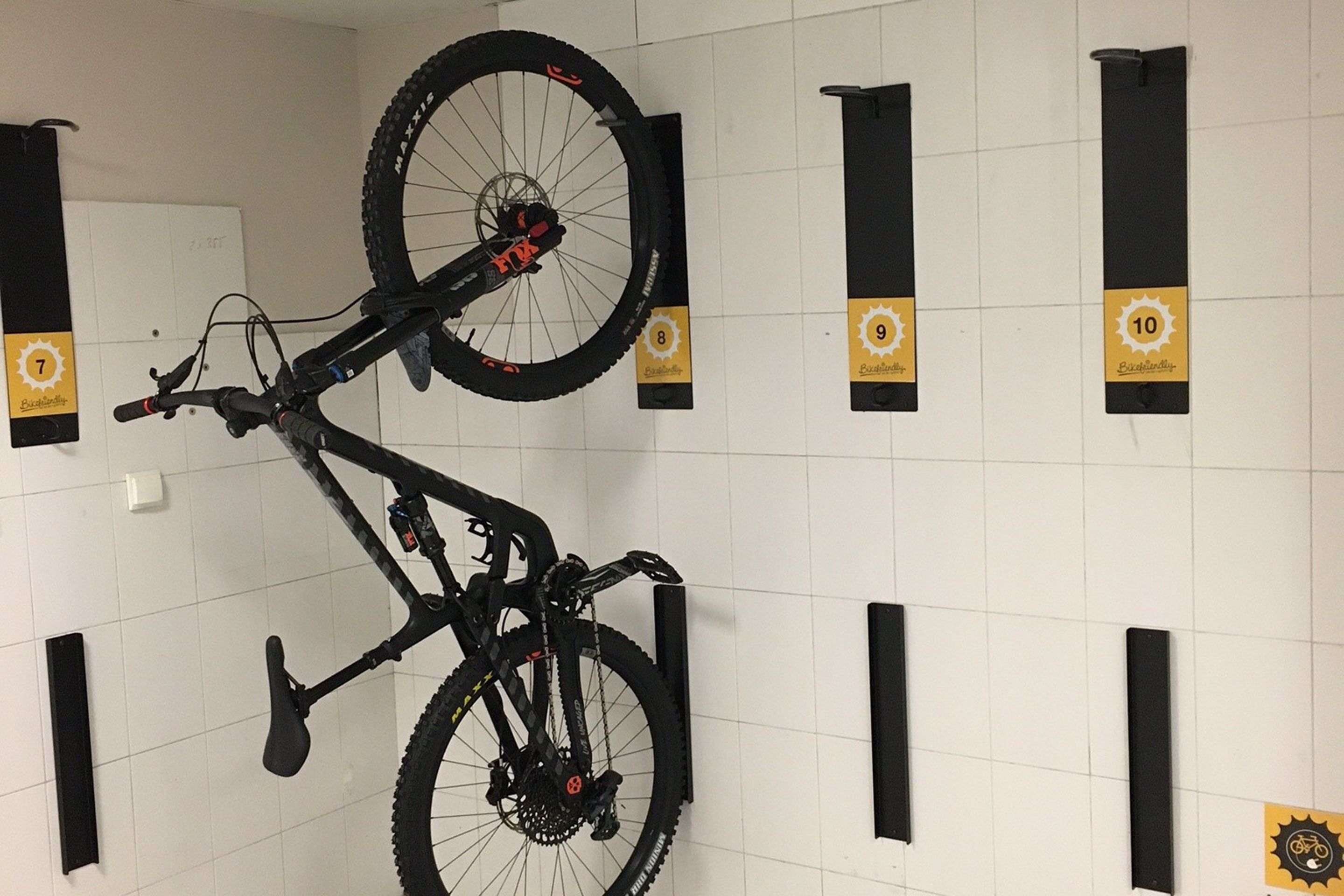 A wall-mounted bike rack with numbered hooks from 8 to 10.