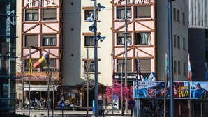 A hotel with a traditional Alpine architectural style, featuring a prominent "HOTEL" sign, multiple windows, and a view of snow-capped mountains in the background. - Font Andorra Hostel by Nexta (La Massana)