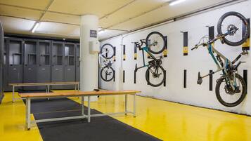 A bike storage area with lockers, a bench, and bicycles mounted on the wall.