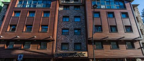Un hotel con fachada de piedra y múltiples ventanas.