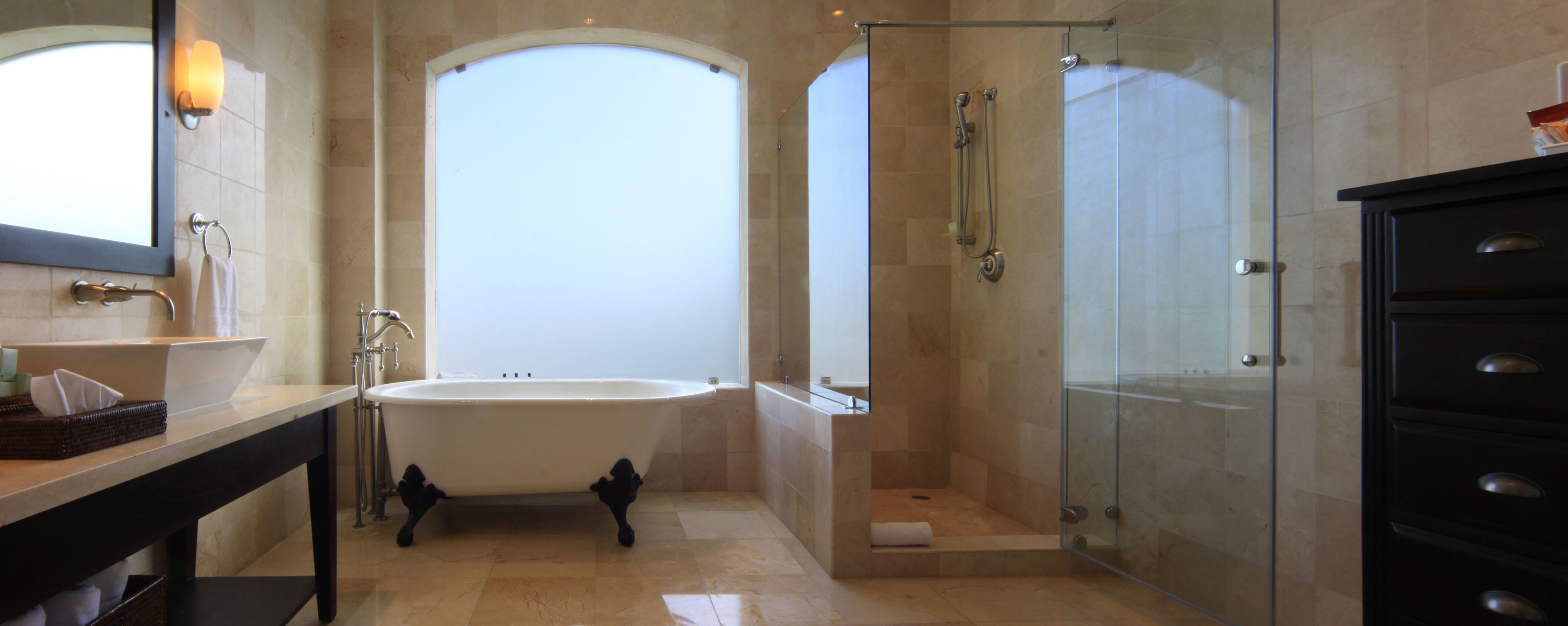 A modern bathroom with a freestanding bathtub, a glass shower enclosure, and a vanity with a mirror and towel rack.