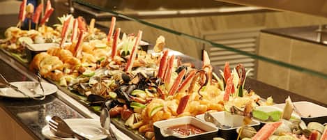 A buffet with a variety of seafood including shrimp, clams, and crab legs.