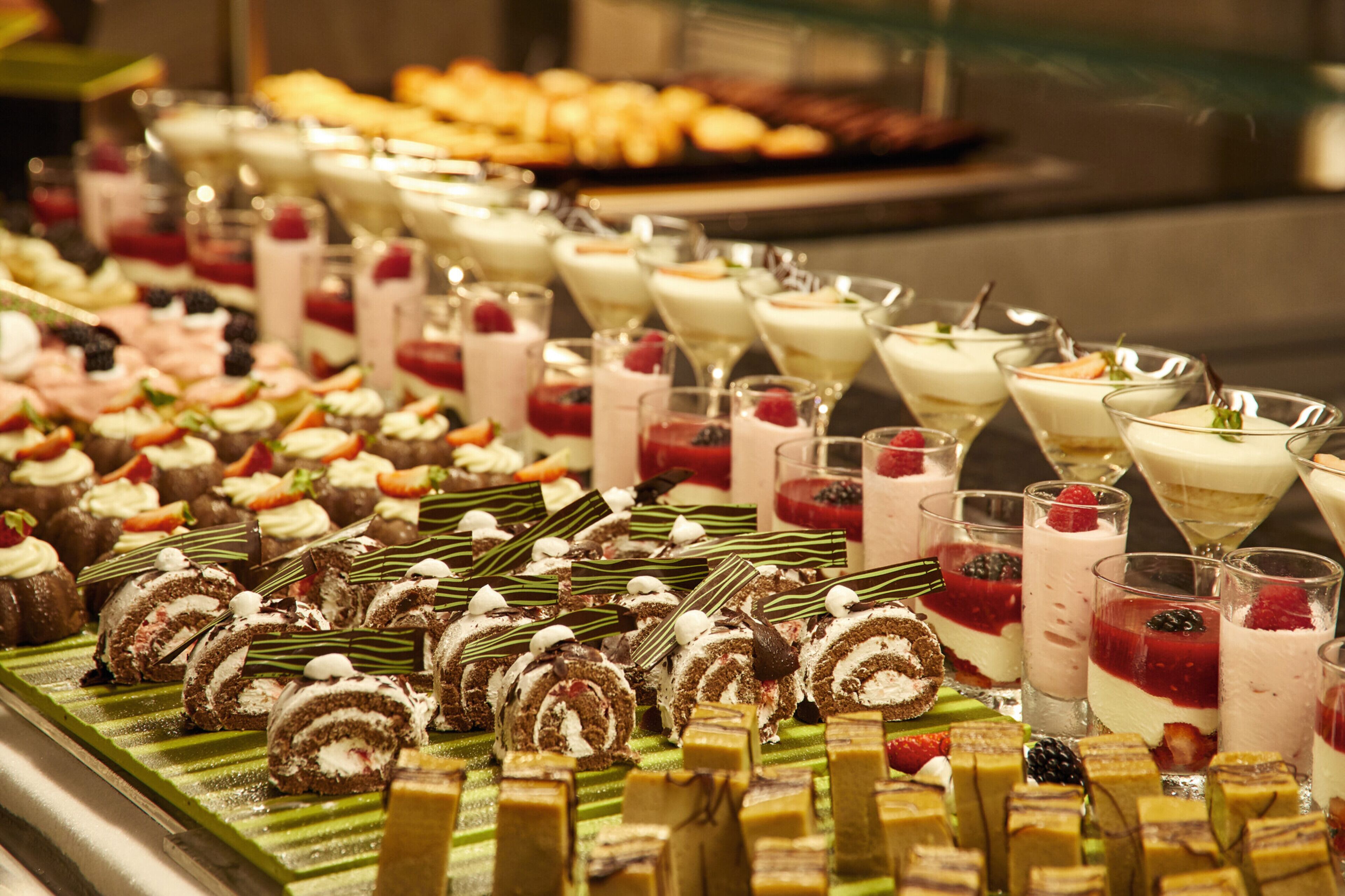 A variety of desserts including cakes, pastries, and desserts in glasses.