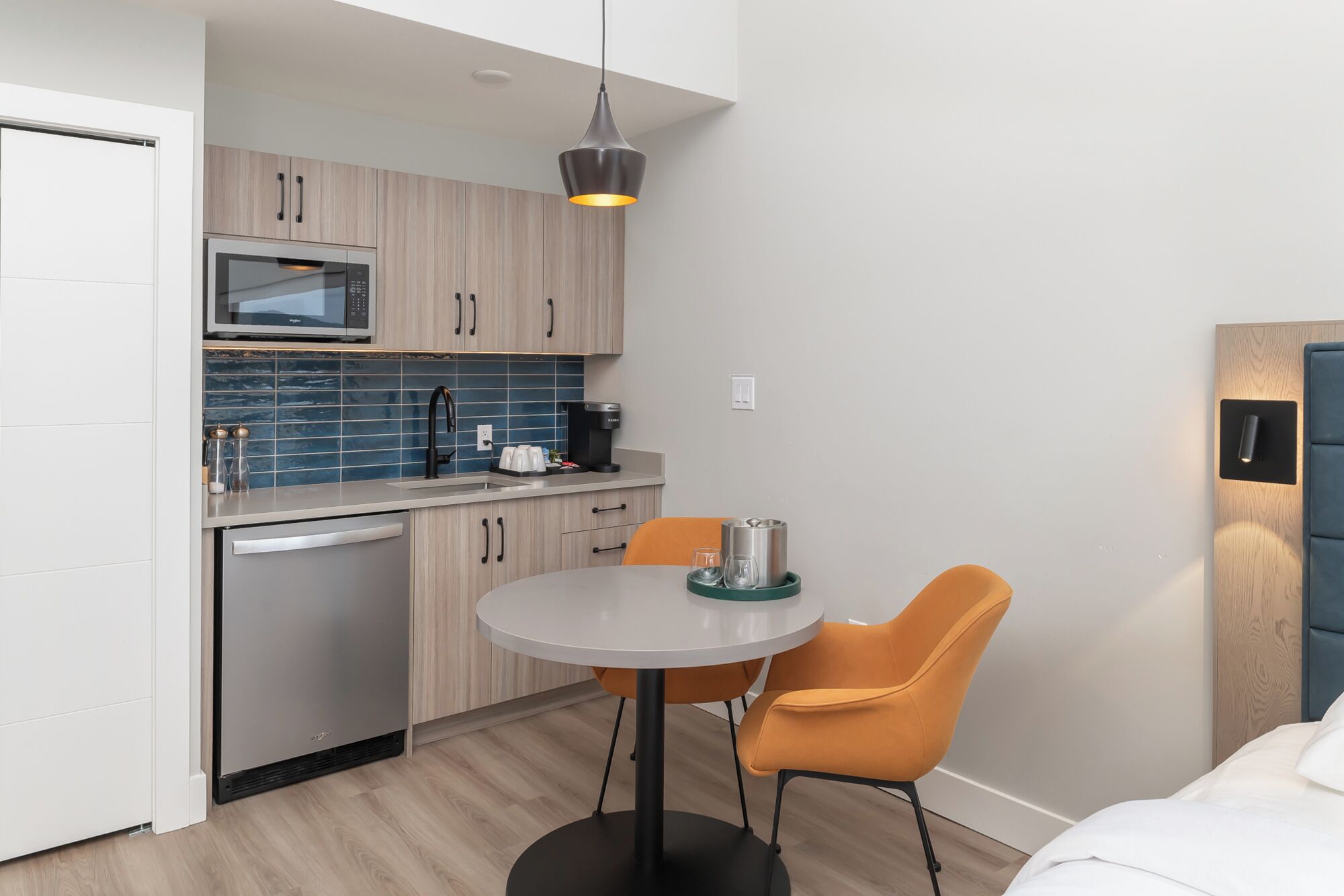 Una cocina compacta con electrodomésticos modernos, un comedor con dos sillas y una pequeña mesa.
