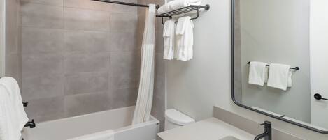 A modern bathroom with a shower, toilet, and sink.