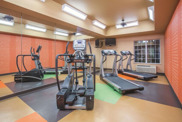 A gym with treadmills, a stationary bike, and a weight machine.