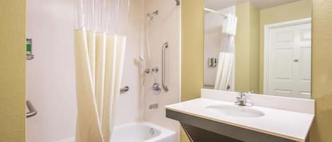 A bathroom with a bathtub, shower, and sink.