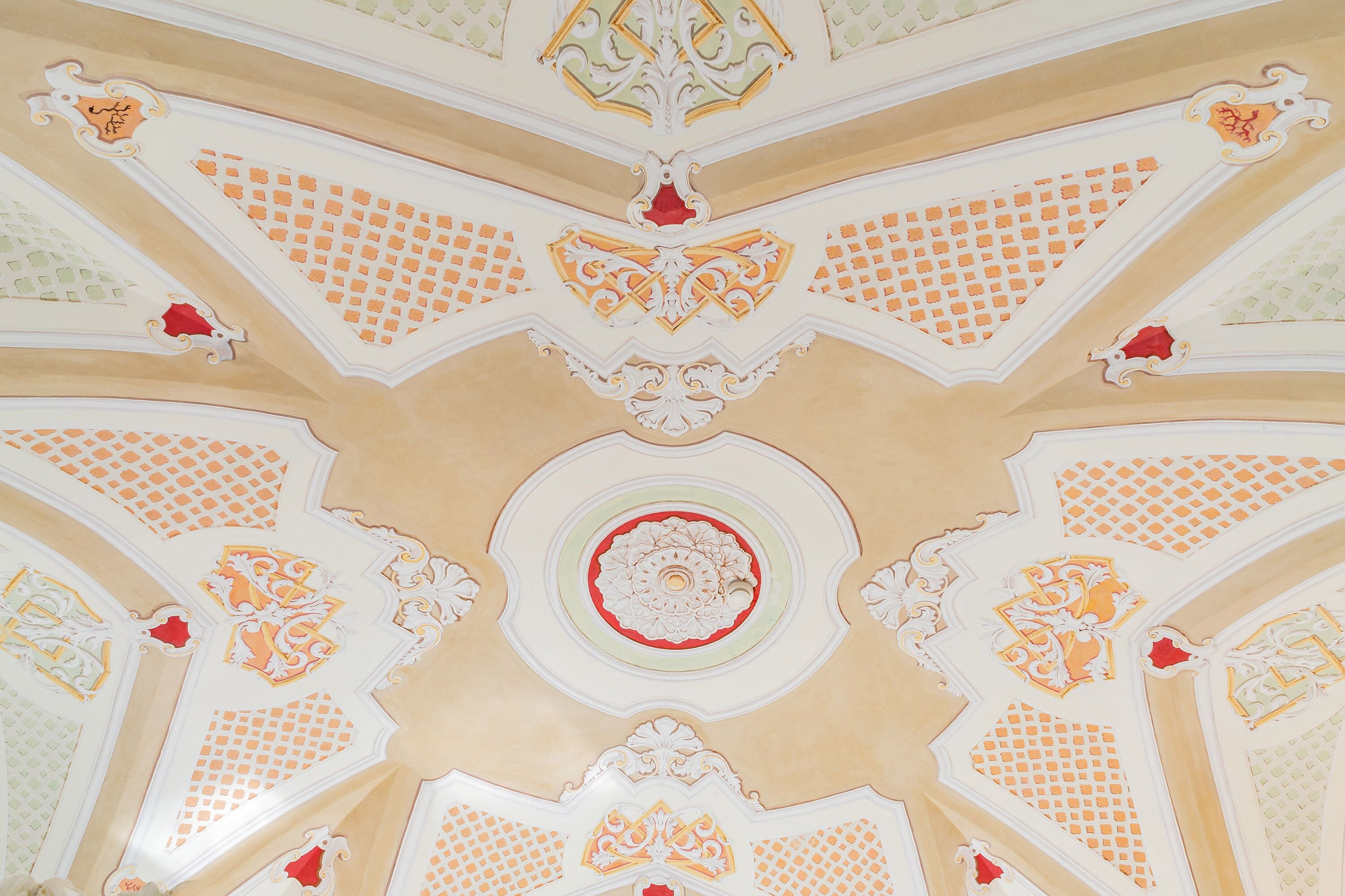 Un plafond orné de motifs géométriques complexes et de décorations florales.