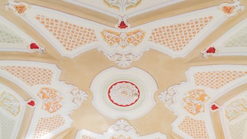 A ceiling with intricate geometric patterns and floral designs.