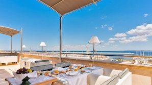 A dining area with a table set for breakfast, overlooking a marina with boats and a clear blue sky. - Palazzo del Corso (Gallipoli)