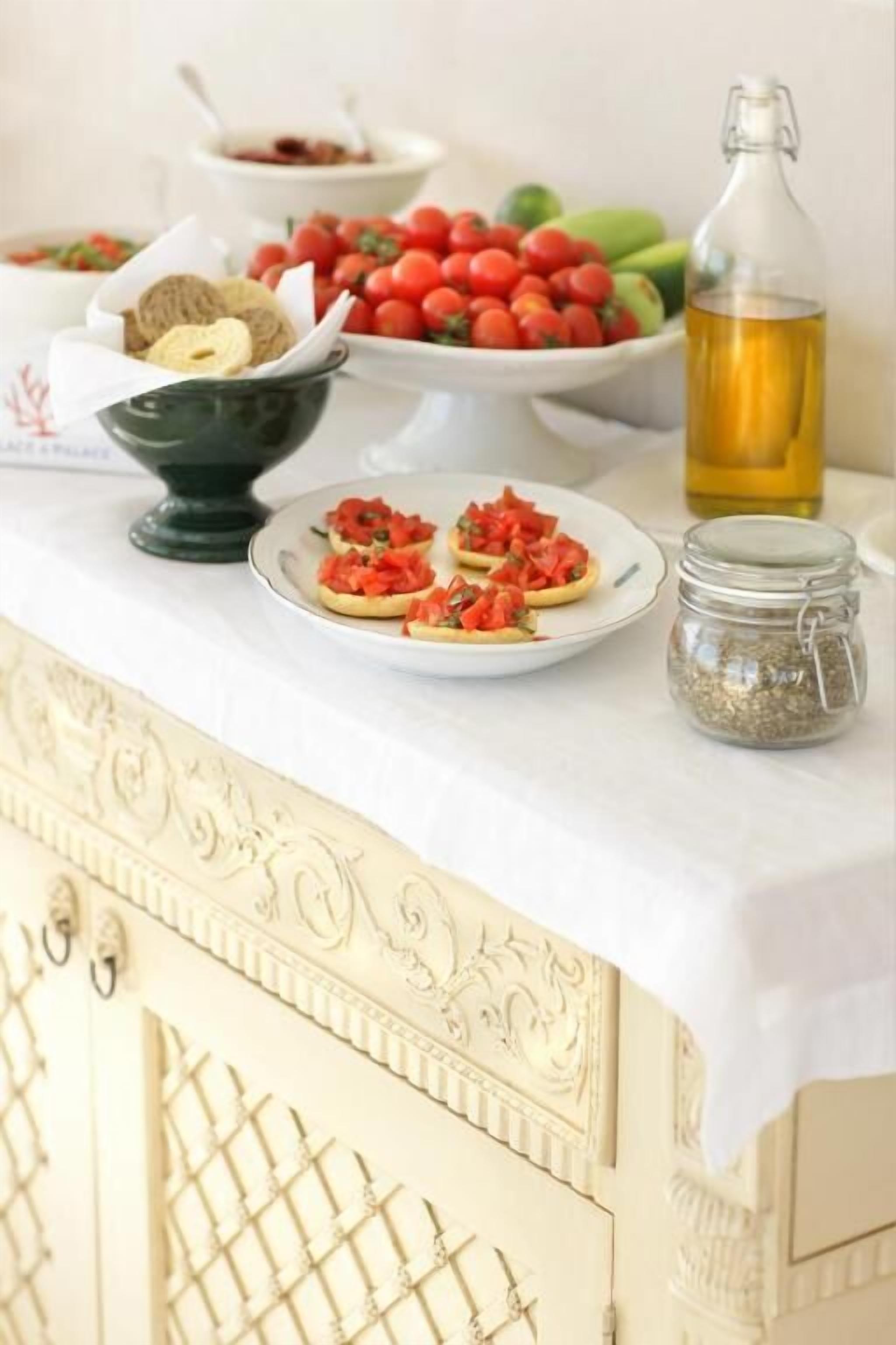 A table with food items, a bottle of oil, and a jar of spices.