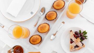 A breakfast setting with toast, jam, and a slice of pie on a white table.